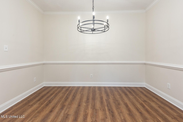 empty room featuring a chandelier, dark hardwood / wood-style floors, and ornamental molding