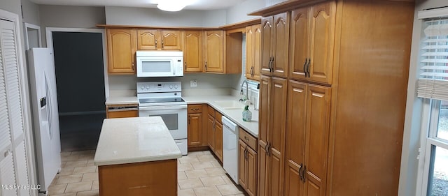 kitchen with a center island, sink, and white appliances