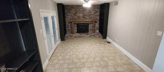 interior space featuring ceiling fan and a brick fireplace