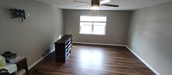 unfurnished room with ceiling fan and dark hardwood / wood-style flooring