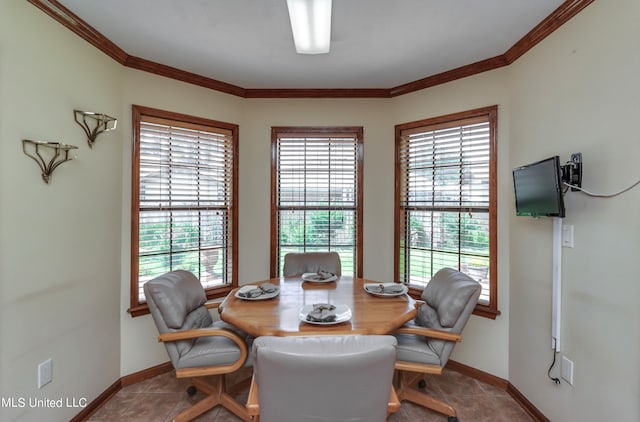 tiled dining space featuring a wealth of natural light and ornamental molding