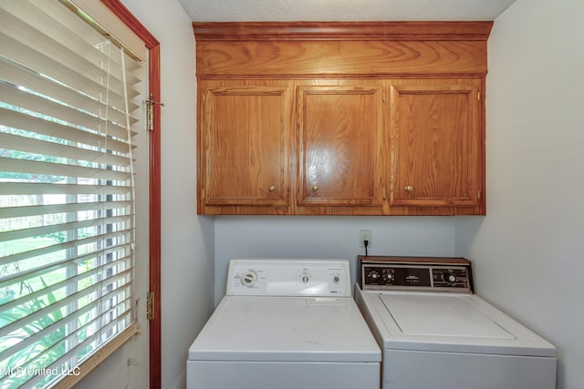 washroom with a textured ceiling, cabinets, and separate washer and dryer