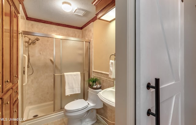 bathroom featuring a textured ceiling, an enclosed shower, toilet, tile patterned floors, and crown molding