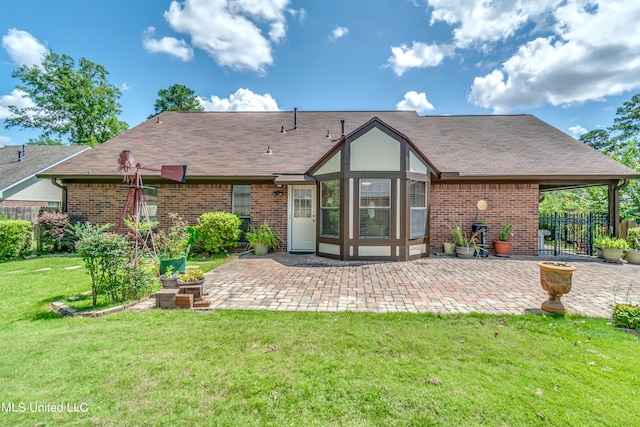 rear view of property featuring a yard and a patio area