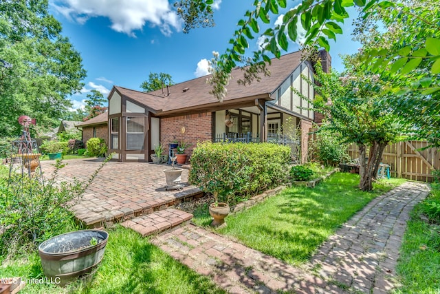 rear view of property with a patio and a lawn