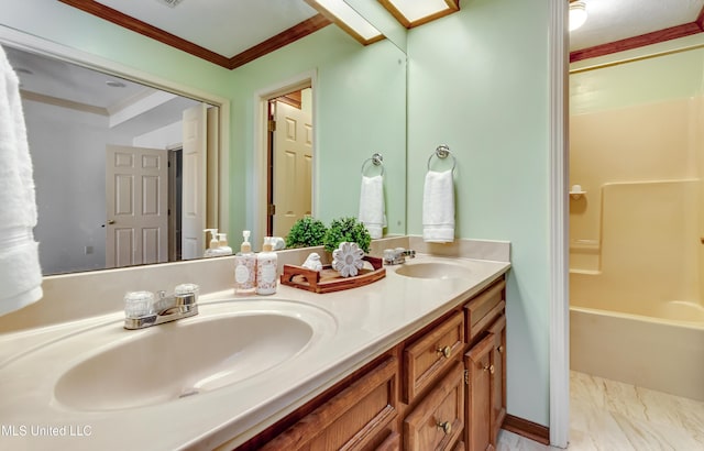 bathroom with ornamental molding, a skylight, and vanity