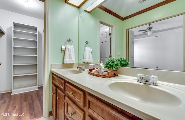 bathroom with hardwood / wood-style flooring, ceiling fan, vanity, and a skylight