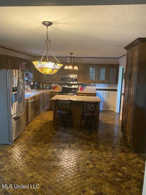710 Eubanks Rd, Alligator, MS 38720 - kitchen featuring stainless steel appliances, a center island, light countertops, a breakfast bar area, and decorative light fixtures