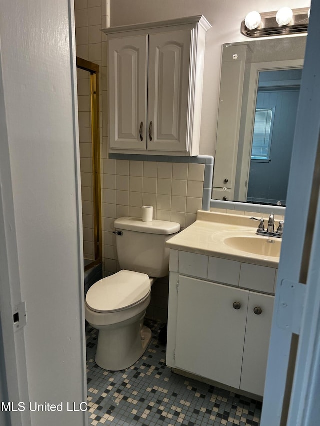 full bathroom with shower / bath combination with glass door, tile patterned flooring, vanity, tasteful backsplash, and toilet