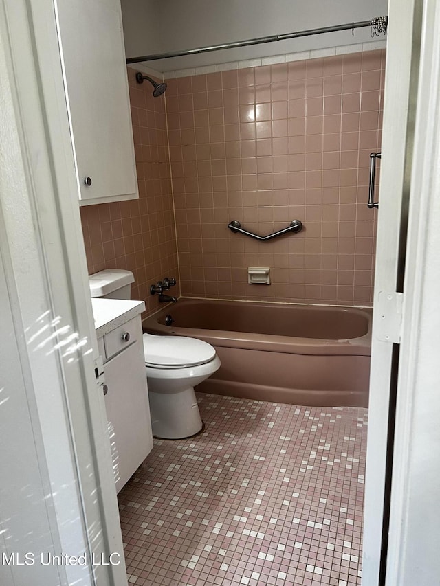 full bathroom with toilet, tiled shower / bath, tile patterned flooring, and vanity