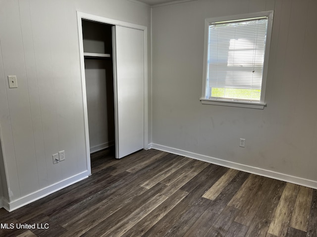 unfurnished bedroom featuring a closet and dark hardwood / wood-style floors