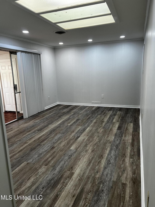 spare room featuring crown molding and dark wood-type flooring