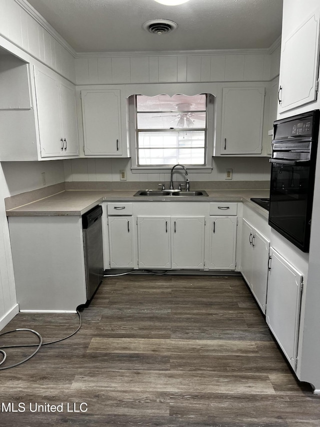 kitchen with white cabinets, sink, stainless steel dishwasher, black oven, and dark hardwood / wood-style flooring