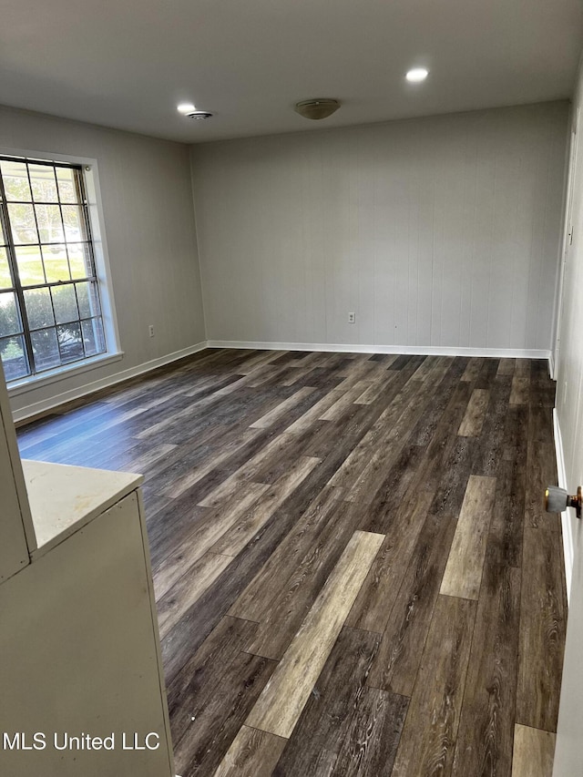 unfurnished room with dark wood-type flooring