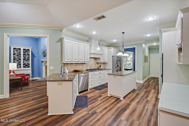 611 Berridge Dr, Ridgeland, MS 39157 - kitchen with stainless steel appliances, premium range hood, a sink, a center island, and white cabinets