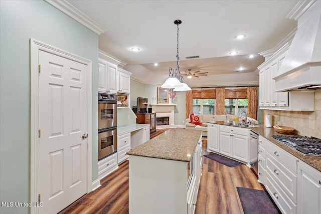 611 Berridge Dr, Ridgeland, MS 39157 - kitchen featuring premium range hood, appliances with stainless steel finishes, a sink, a ceiling fan, and white cabinetry