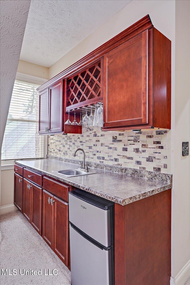 611 Berridge Dr, Ridgeland, MS 39157 - kitchen with freestanding refrigerator, a sink, decorative backsplash, baseboards, and dark brown cabinets