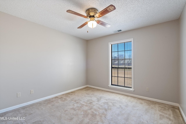 carpeted empty room featuring visible vents, a textured ceiling, baseboards, and a ceiling fan