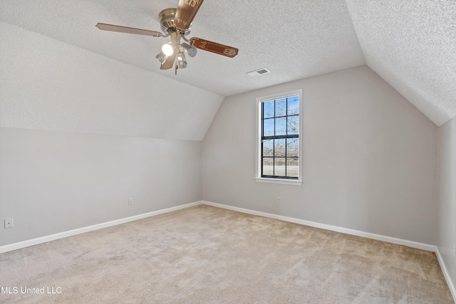 bonus room with baseboards, a textured ceiling, carpet flooring, and vaulted ceiling