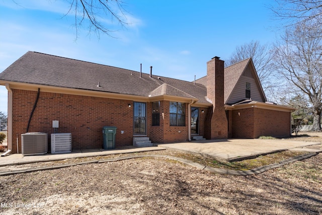 back of house with a patio area, brick siding, and central AC