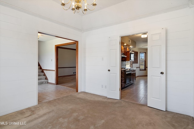 empty room featuring tile patterned flooring, stairway, carpet flooring, and a chandelier