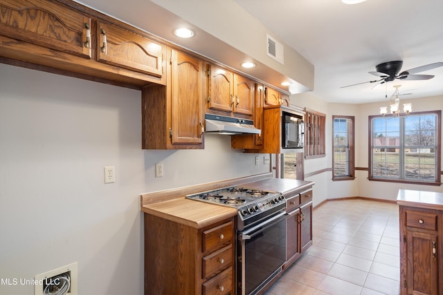 kitchen with visible vents, light tile patterned flooring, gas range oven, under cabinet range hood, and black microwave