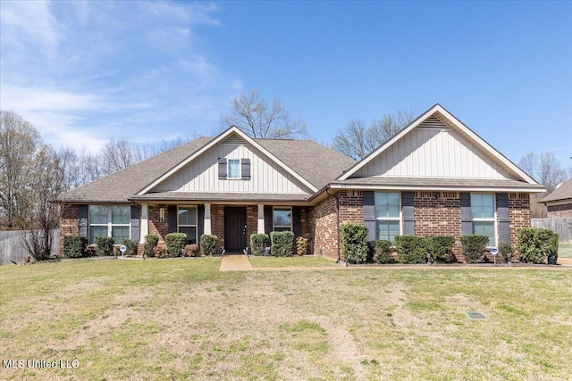 craftsman-style house with a front yard, fence, board and batten siding, brick siding, and a shingled roof