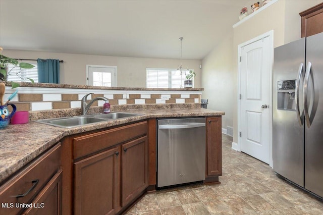 kitchen featuring a sink, a wealth of natural light, appliances with stainless steel finishes, and an inviting chandelier