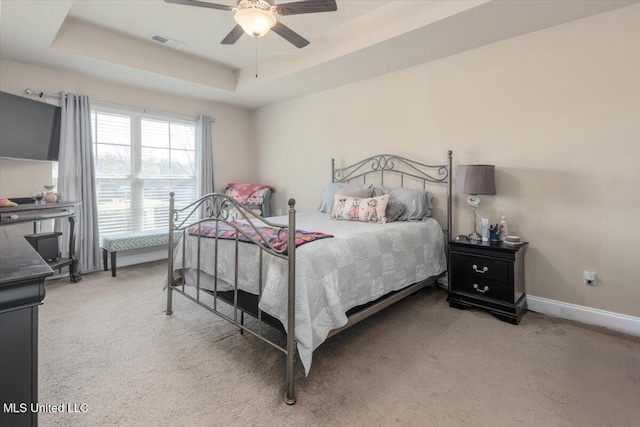 bedroom with baseboards, visible vents, carpet, and a raised ceiling