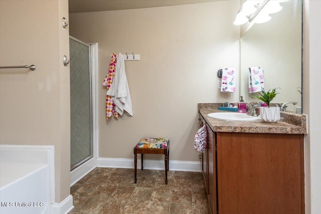 bathroom with a shower stall, baseboards, and vanity