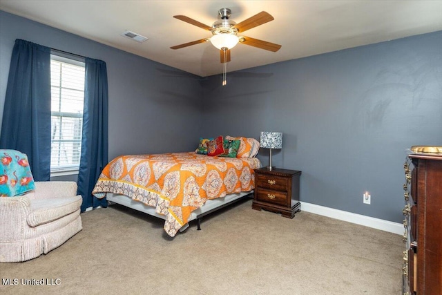 bedroom with baseboards, carpet floors, visible vents, and a ceiling fan