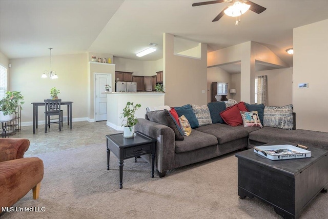 living room featuring ceiling fan with notable chandelier, vaulted ceiling, light colored carpet, and baseboards