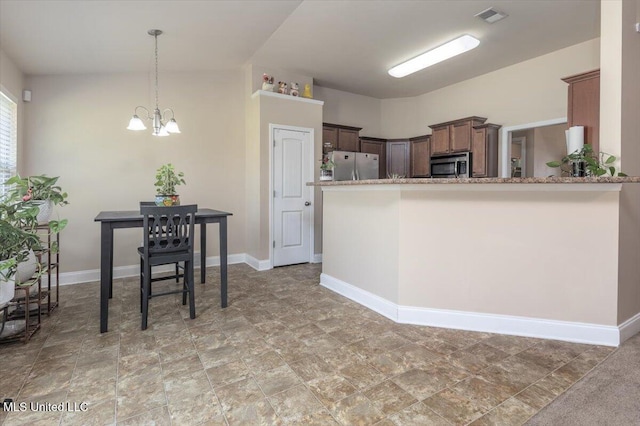 kitchen featuring visible vents, baseboards, light stone countertops, stainless steel appliances, and a notable chandelier