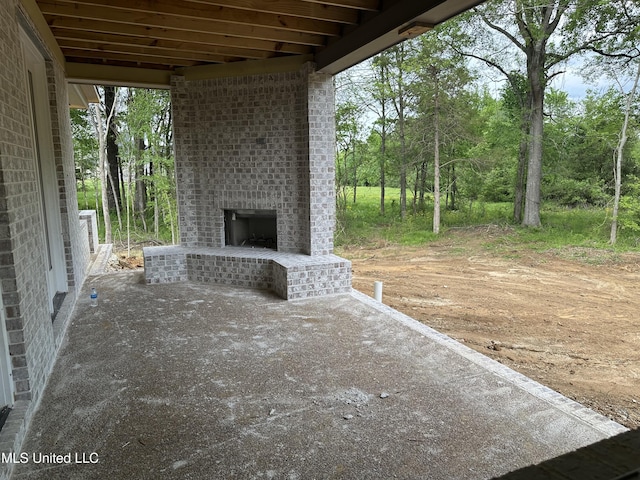 view of patio with an outdoor brick fireplace