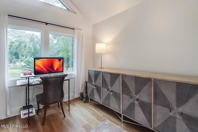 home office featuring wood finished floors and vaulted ceiling