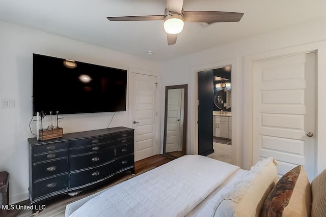 bedroom featuring ceiling fan, wood finished floors, and ensuite bath