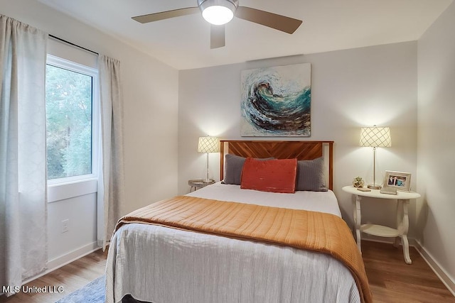bedroom with baseboards, ceiling fan, and wood finished floors