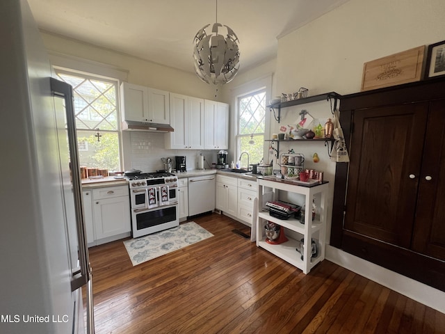 kitchen featuring dark wood-type flooring, open shelves, under cabinet range hood, a sink, and white appliances