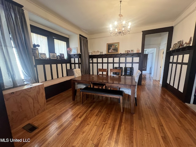 dining area featuring hardwood / wood-style floors, visible vents, and a chandelier