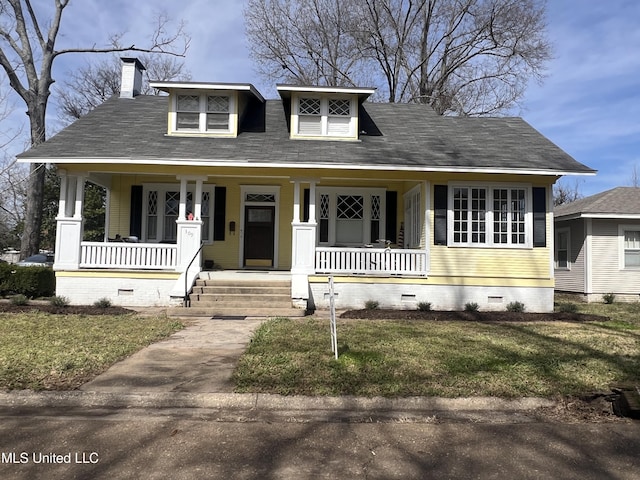 bungalow-style home with a porch, a chimney, a front lawn, and crawl space