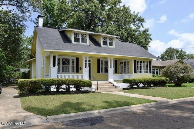 bungalow-style house featuring covered porch and a front yard