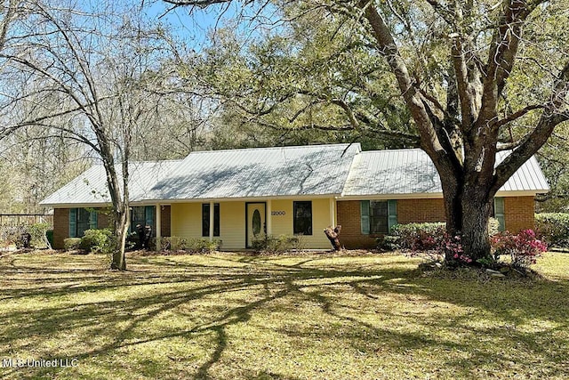 single story home with brick siding, metal roof, and a front yard