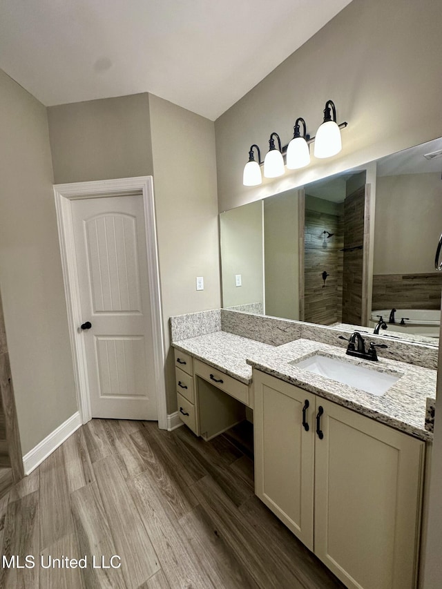 4049 Courtyard Dr, Southaven, MS 38671 - bathroom with wood finished floors, vanity, tiled shower, and baseboards