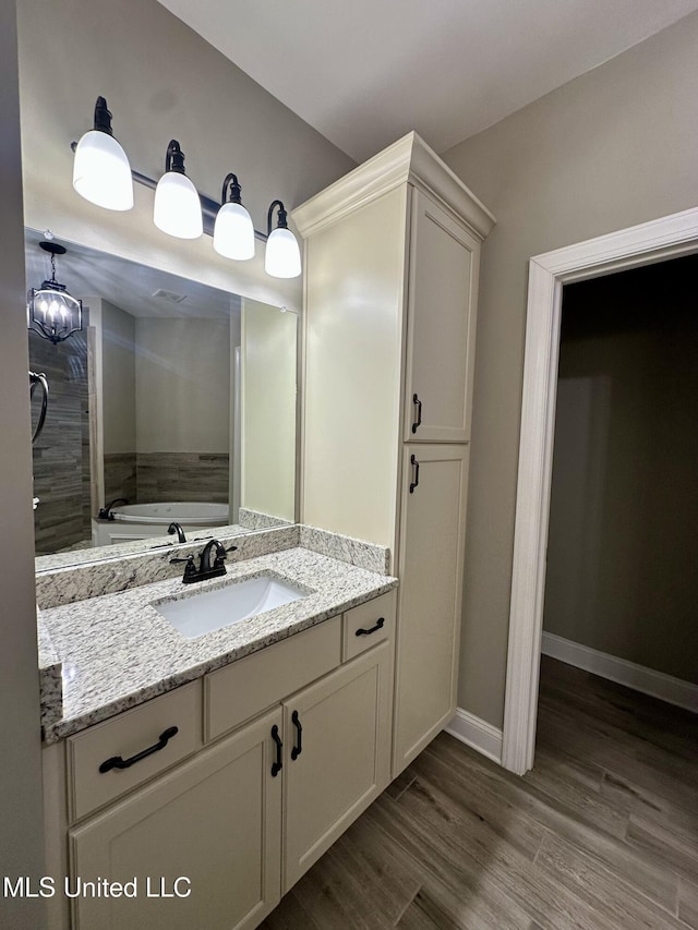 4049 Courtyard Dr, Southaven, MS 38671 - full bath with vanity, wood finished floors, a bath, and baseboards