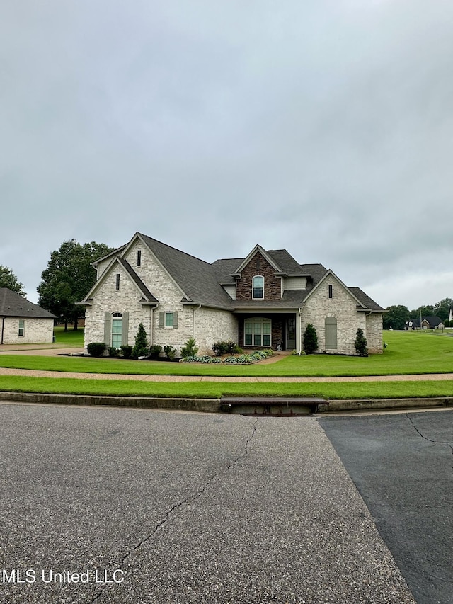 4049 Courtyard Dr, Southaven, MS 38671 - view of front of property with stone siding, a front yard, and a shingled roof