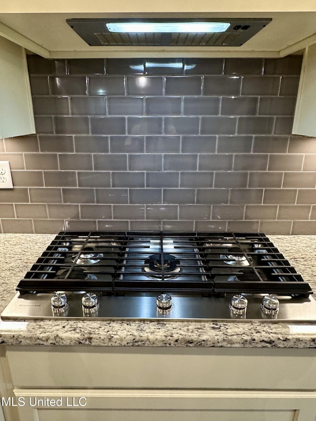 4049 Courtyard Dr, Southaven, MS 38671 - kitchen view of stainless steel gas stovetop, decorative backsplash, and light stone counters