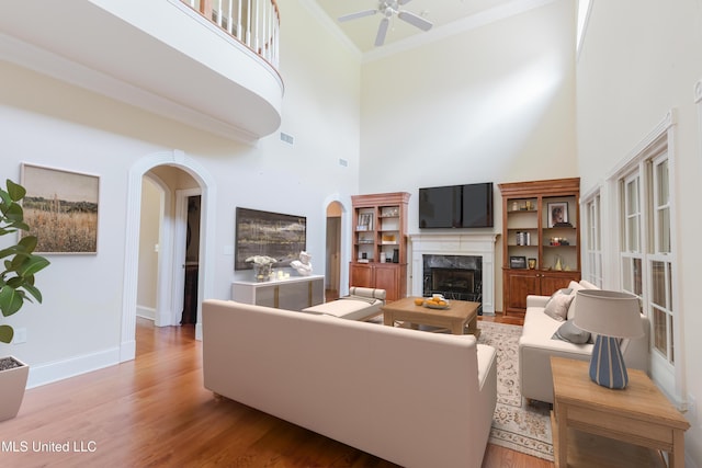 104 Overbrook Hl, Ridgeland, MS 39157 - living area with arched walkways, a towering ceiling, a premium fireplace, ceiling fan, and ornamental molding
