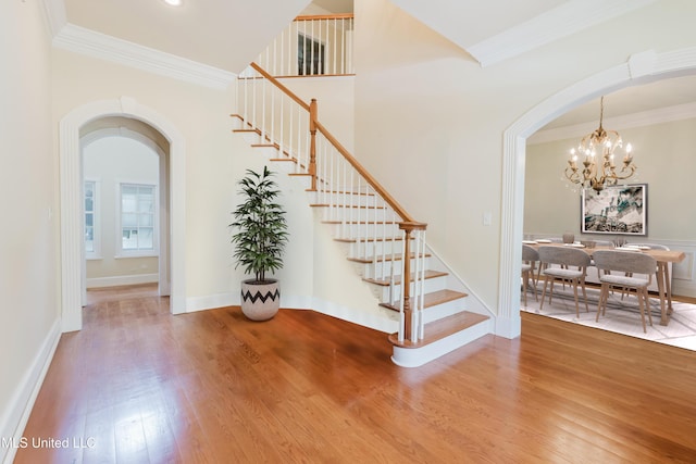 104 Overbrook Hl, Ridgeland, MS 39157 - staircase with arched walkways, wood finished floors, ornamental molding, and a chandelier