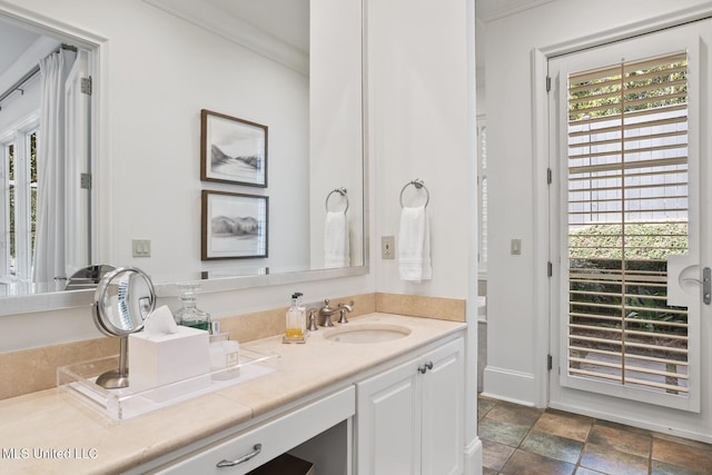 bathroom featuring ornamental molding, stone finish flooring, vanity, and baseboards