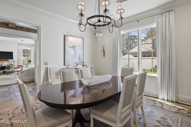 dining space featuring a chandelier, visible vents, light wood-style floors, baseboards, and crown molding